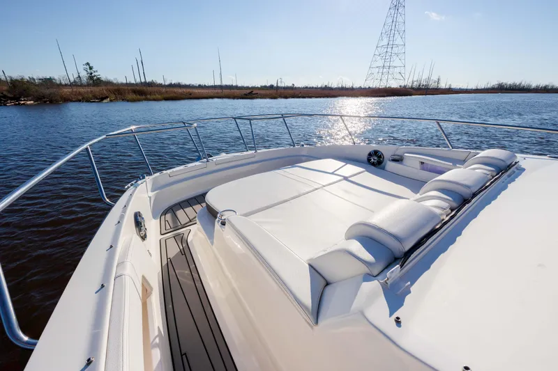 Slide: The Image of 2019 Sea Ray 320 Sundancer OB boat on calm water with sunpad and railing. - 42