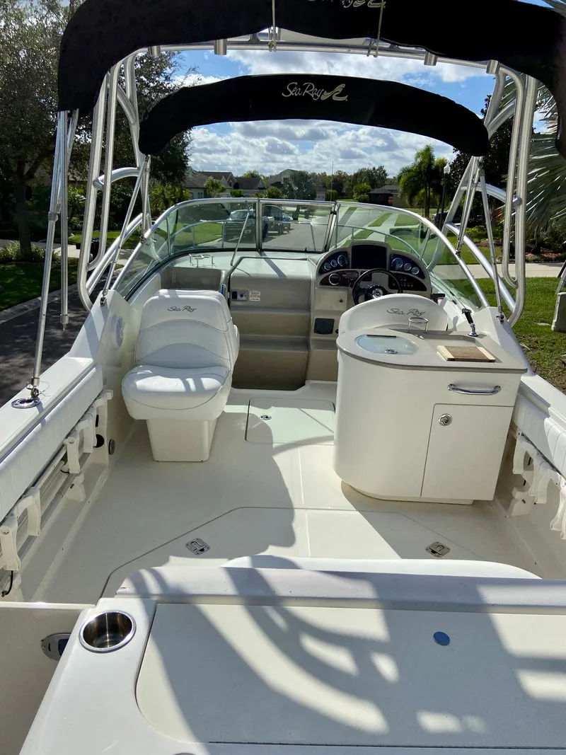 Slide: The Image of 2006 Sea Ray 270 Amberjack boat interior with seating and helm, under a sunny sky. - 11