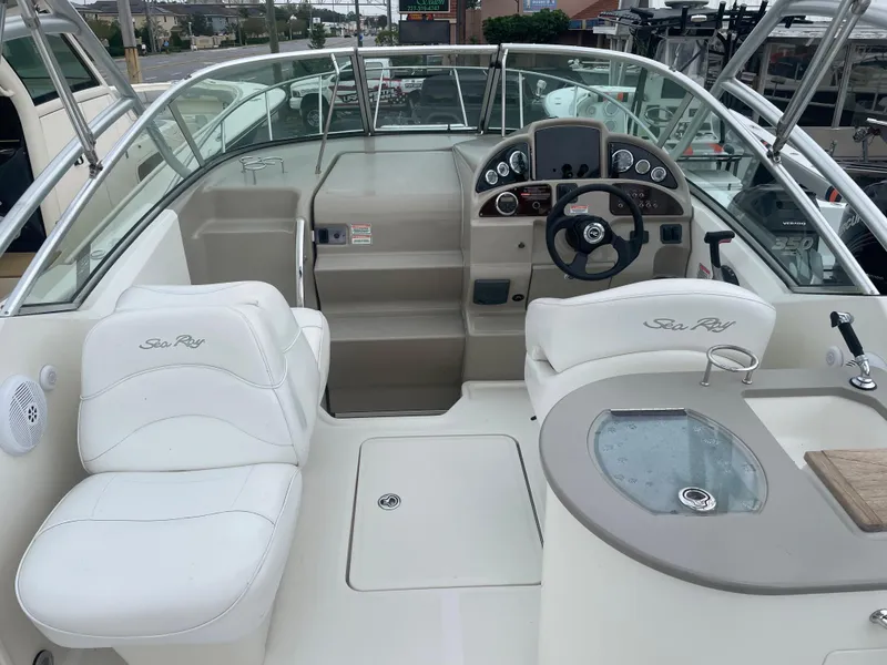 Slide: The Image of 2006 Sea Ray 270 Amberjack boat interior with white seating and control panel. - 14