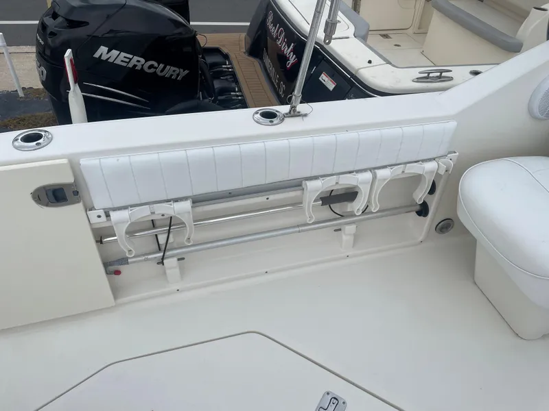 Slide: The Image of 2006 Sea Ray 270 Amberjack boat interior with Mercury engine, featuring rod holders and seating. - 19