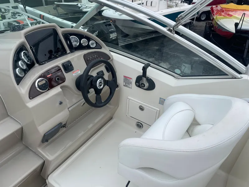 Slide: The Image of 2006 Sea Ray 270 Amberjack boat cockpit with steering wheel and white captain's chair. - 21