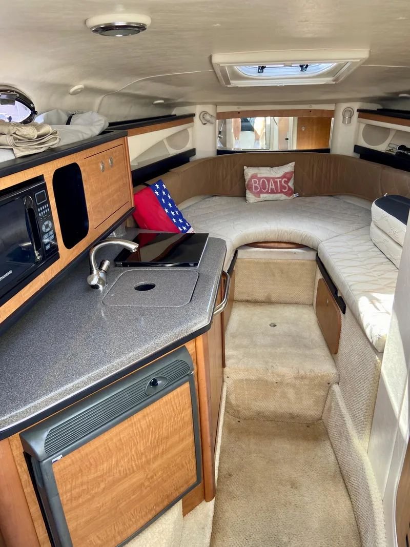 Slide: The Image of 2006 Sea Ray 270 Amberjack cabin interior with kitchenette and seating area. - 31