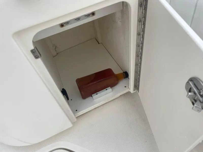 Slide: The Image of Open storage compartment on 2006 Sea Ray 270 Amberjack boat with a bottle inside. - 33