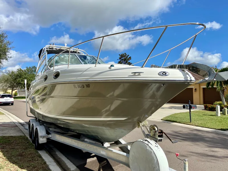 Slide: The Image of 2006 Sea Ray 270 Amberjack boat on trailer, parked in suburban neighborhood. - 5