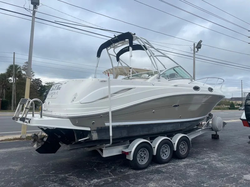 Slide: The Image of 2006 Sea Ray 270 Amberjack boat on a trailer, parked outdoors. - 7