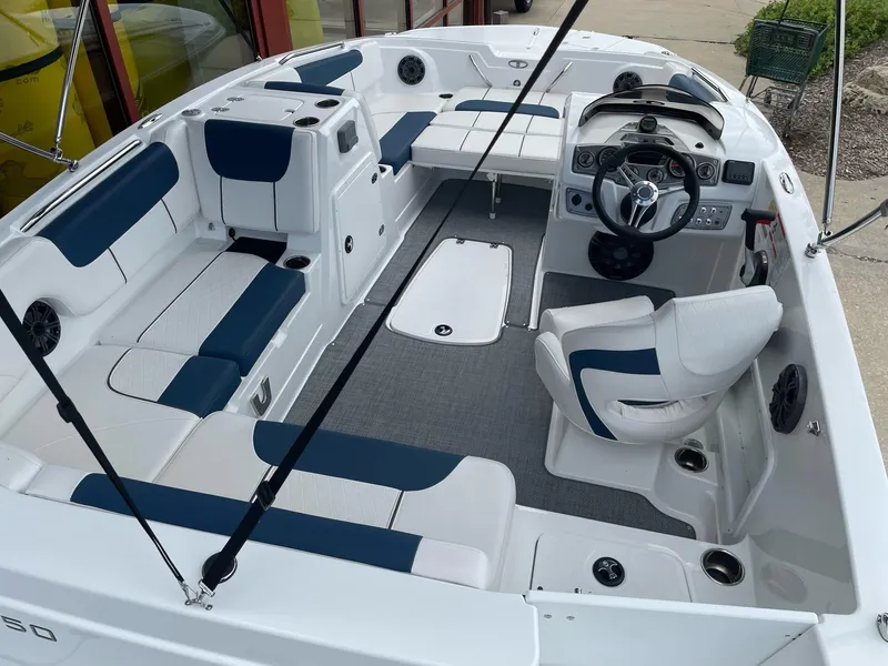 Slide: The Image of 2023 Tahoe 1950 boat interior with white and blue seating, steering console, and spacious layout. - 5