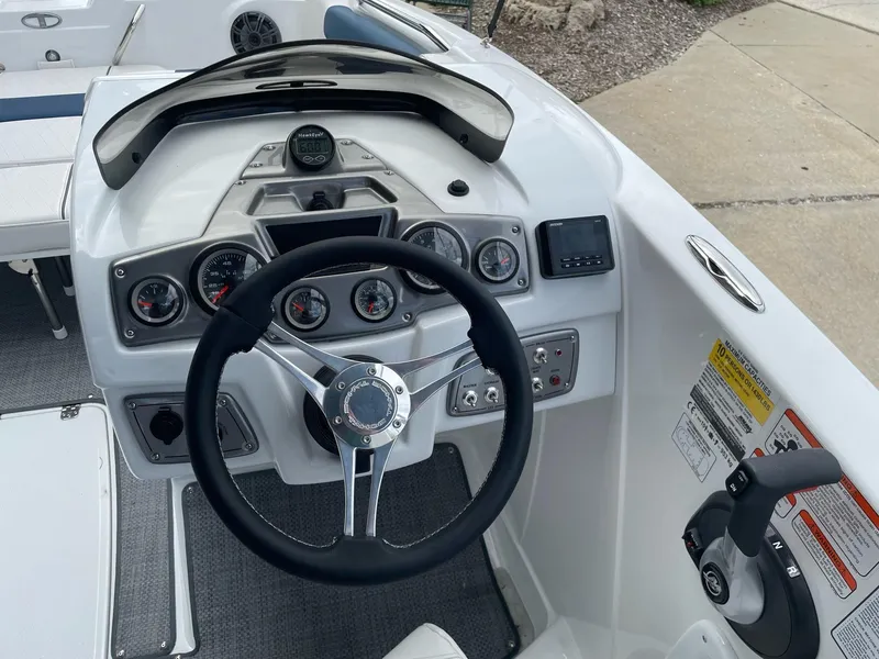 Slide: The Image of 2023 Tahoe 1950 boat dashboard with steering wheel and control panel. - 6