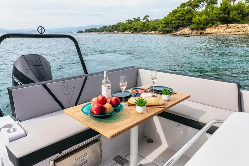 Slide: The Image of RYCK 280 boat interior with dining setup, featuring fruit and wine, 2023 model. - 12