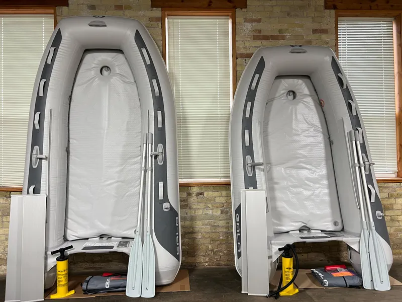 Slide: The Image of 2023 Gala F270A inflatable boats with paddles and pumps, displayed upright indoors. - 4