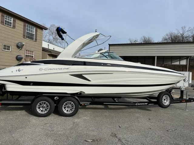 Slide: The Image of 2023 Crownline 290 SS boat on a trailer in a parking lot. - 0
