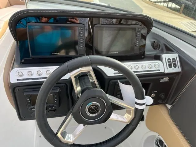 Slide: The Image of 2023 Crownline 290 SS boat dashboard with dual Garmin displays and steering wheel. - 3