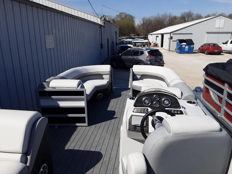 Slide: The Image of 2023 Lowe SS 230 pontoon boat with spacious seating and modern dashboard. - 2