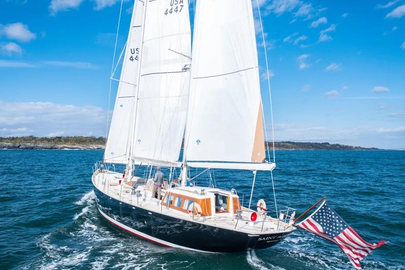 Slide: The Image of Sailing ketch by New England Boatworks, 1995, cruising on open water with American flag. - 29