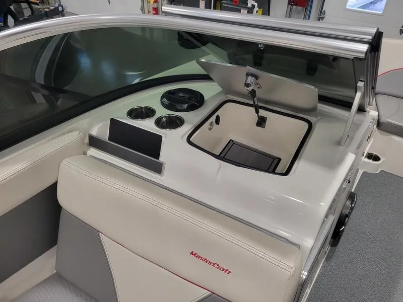 Slide: The Image of 2018 MasterCraft XT22 boat interior with storage compartment and cup holders. - 24