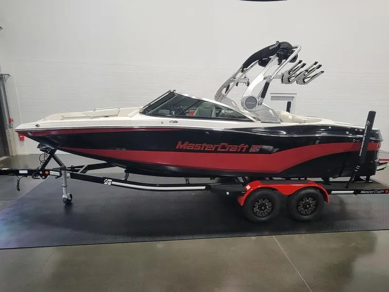 Slide: The Image of 2018 MasterCraft XT22 boat on trailer, black and red design, indoor showroom. - 9