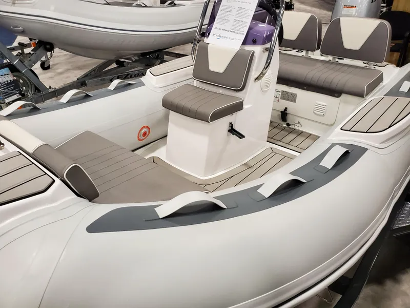 Slide: The Image of 2023 Gala V330 inflatable boat with seating and console, displayed indoors. - 1