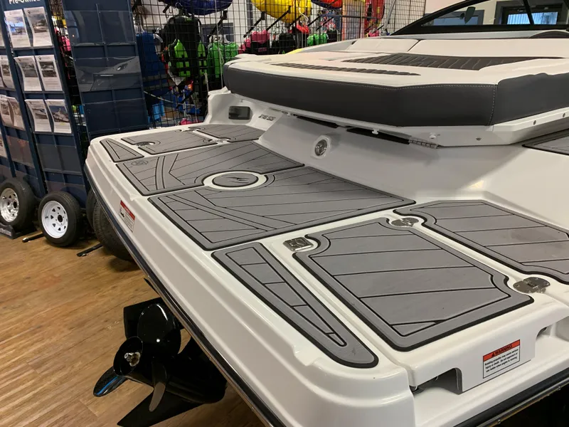 Slide: The Image of 2023 Monterey 218 Super Sport boat with sleek deck design in showroom. - 3