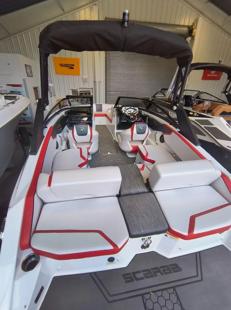 Slide: The Image of 2023 Scarab 195 ID boat interior with red and white seating, in a showroom setting. - 6