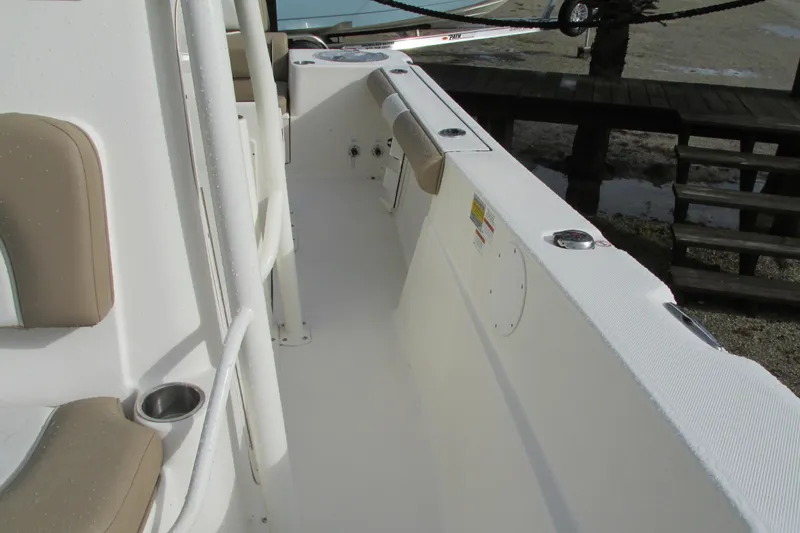 Slide: The Image of 2023 Sea Born LX22 Center Console boat interior with beige seating and cup holders. - 29