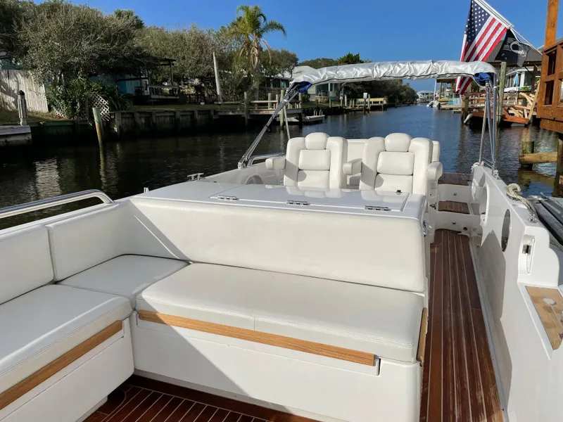 Slide: The Image of 2011 Novurania Chapman Transition 28 boat with white seating, docked in a scenic canal. - 11