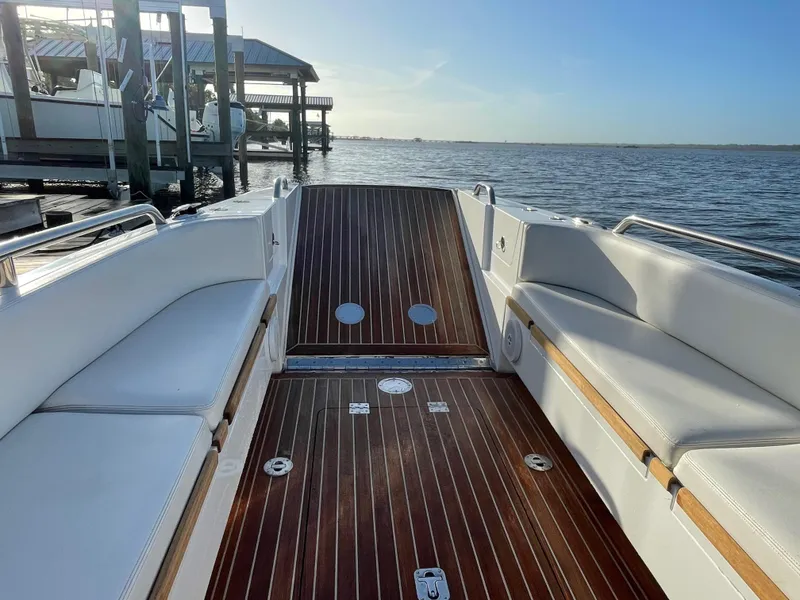 Slide: The Image of 2011 Novurania Chapman Transition 28 boat interior with wooden deck and white seating. - 6