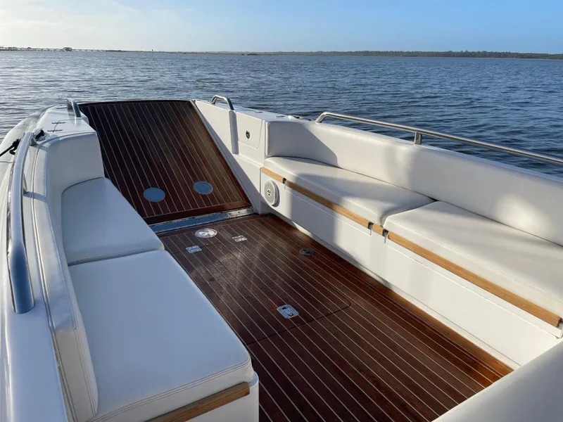 Slide: The Image of 2011 Novurania Chapman Transition 28 boat interior with white seating and wooden deck. - 8