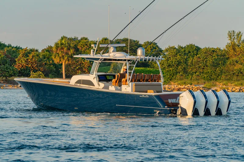 Slide: The Image of 2025 Valhalla Boatworks V-46 cruising on water with lush greenery in the background. - 6
