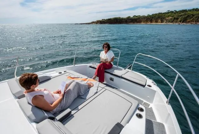 Slide: The Image of 2024 Jeanneau NC 1295 Fly yacht with two people relaxing on deck, ocean view. - 11