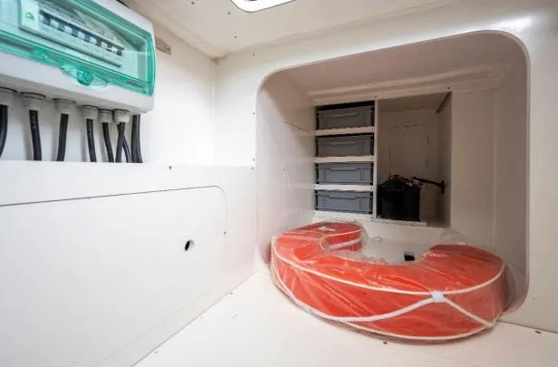 Slide: The Image of 2024 Jeanneau NC 1295 Fly storage area with life preserver and electrical panel. - 15