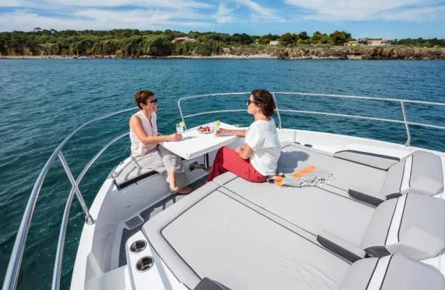 Slide: The Image of Two people enjoying drinks on a 2024 Jeanneau NC 1295 Fly yacht. - 17