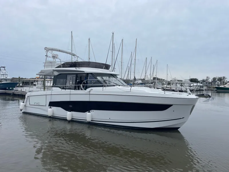 Slide: The Image of 2024 Jeanneau NC 1295 FLY yacht docked in a marina. - 21