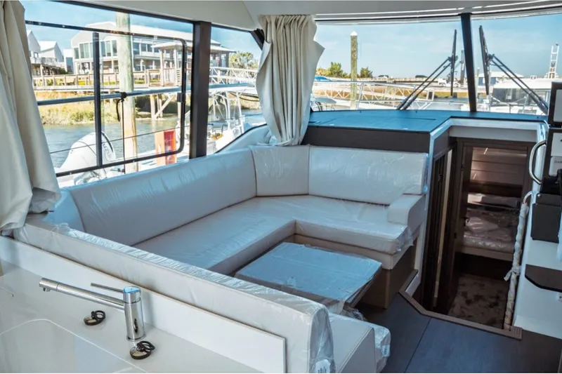 Slide: The Image of Interior of 2026 Jeanneau NC 1295 Fly yacht with modern seating and large windows. - 27