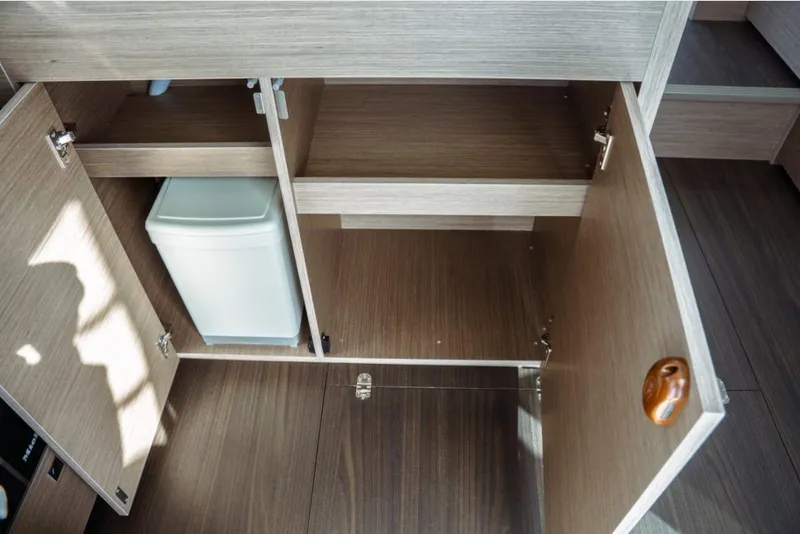 Slide: The Image of Open wooden cabinet with trash bin inside, Jeanneau NC 1295 Fly 2026 model. - 42