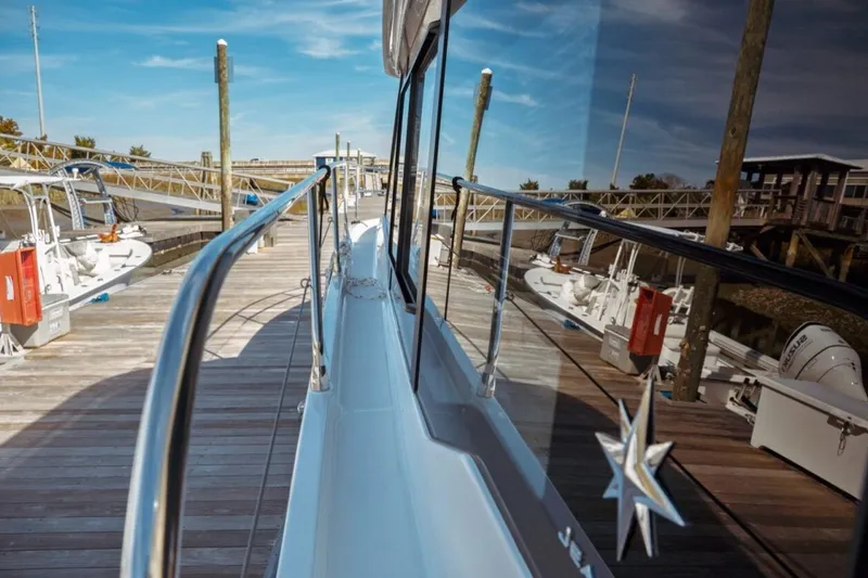 Slide: The Image of 2026 Jeanneau NC 1295 Fly yacht docked at a marina, reflecting clear blue skies. - 50