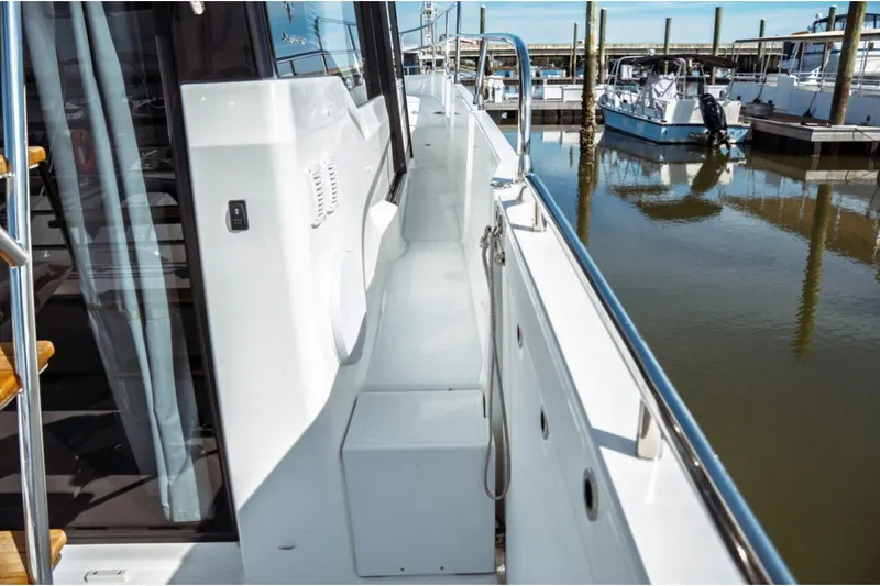 Slide: The Image of 2026 Jeanneau NC 1295 Fly yacht docked, showcasing sleek side deck and modern design. - 57