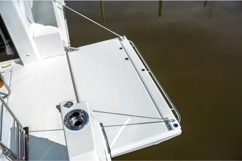 Slide: The Image of Jeanneau NC 1295 Fly 2026 boat deck with stainless steel railing and cup holder. - 60