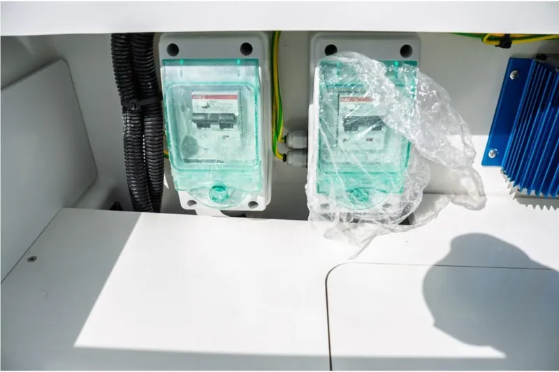 Slide: The Image of Electrical components on Jeanneau NC 1295 Fly 2026 boat, featuring protective covers and wiring. - 62