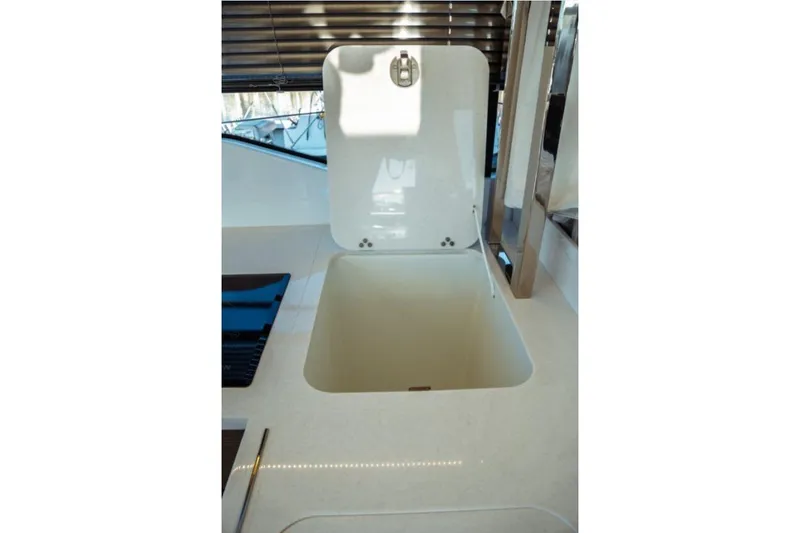 Slide: The Image of 2026 Jeanneau NC 1295 Fly yacht interior with open storage compartment. - 78