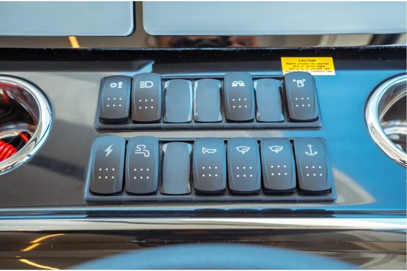 Slide: The Image of Control panel of 2026 Jeanneau NC 1295 Fly boat with labeled switches. - 97