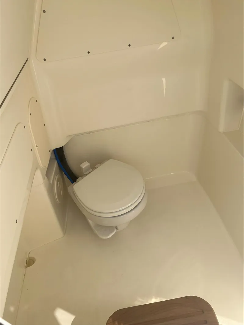 Slide: The Image of 2023 Boston Whaler 280 Dauntless boat interior with a compact marine toilet. - 19