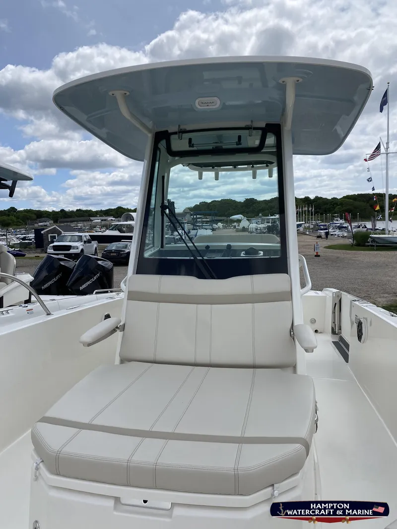 Slide: The Image of 2023 Boston Whaler 280 Dauntless boat with cushioned seating and canopy, docked at marina. - 8