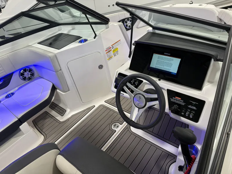 Slide: The Image of 2023 Sea Ray SPX 190 boat interior with modern dashboard and blue ambient lighting. - 18