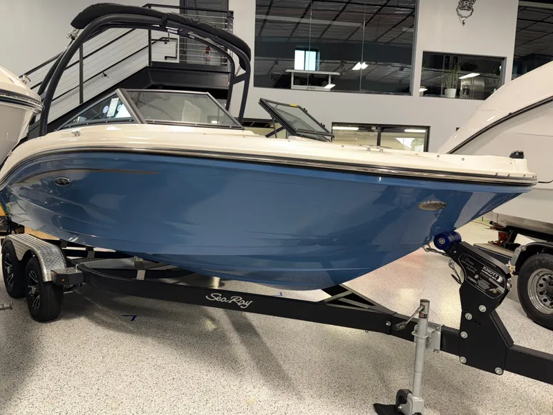 Slide: The Image of 2023 Sea Ray SPX 190 boat in showroom, blue hull, on trailer. - 2