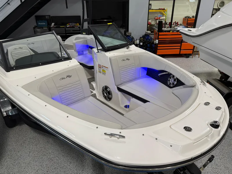 Slide: The Image of 2023 Sea Ray SPX 190 boat with illuminated interior in a showroom setting. - 23