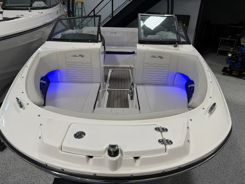 Slide: The Image of 2023 Sea Ray SPX 190 boat interior with blue LED lighting and cushioned seating. - 24