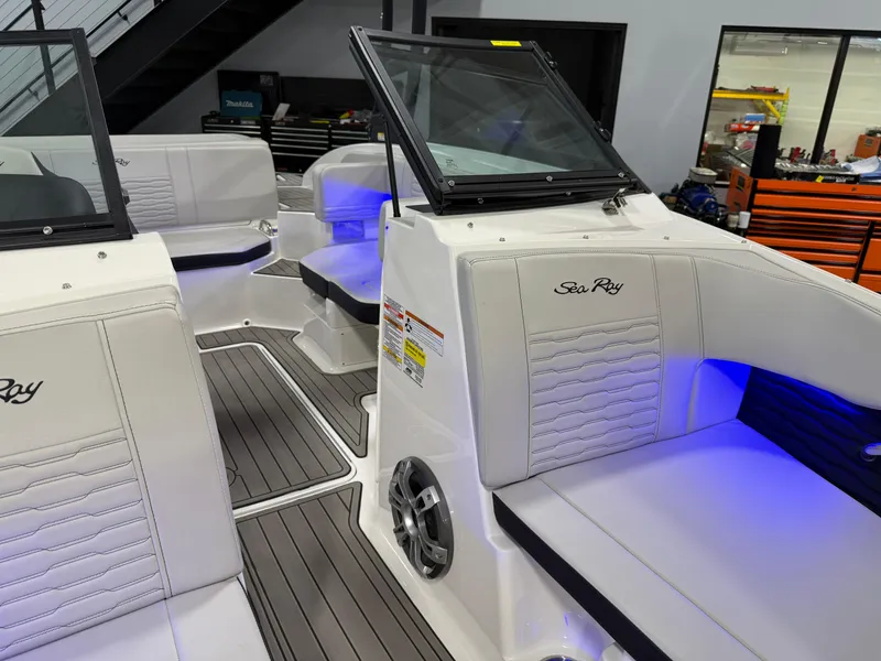 Slide: The Image of 2023 Sea Ray SPX 190 boat interior with white seating and blue LED lighting. - 26