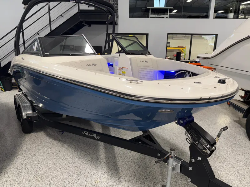 Slide: The Image of 2023 Sea Ray SPX 190 boat on display in showroom, blue hull, on trailer. - 3