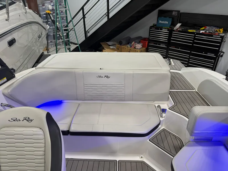 Slide: The Image of 2023 Sea Ray SPX 190 boat interior with white seating and blue accent lighting. - 32