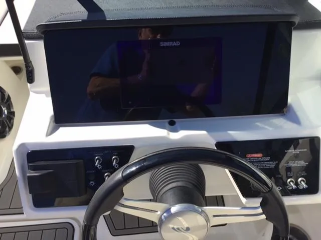 Slide: The Image of 2023 Sea Ray SPX 190 dashboard with steering wheel and Simrad display. - 38