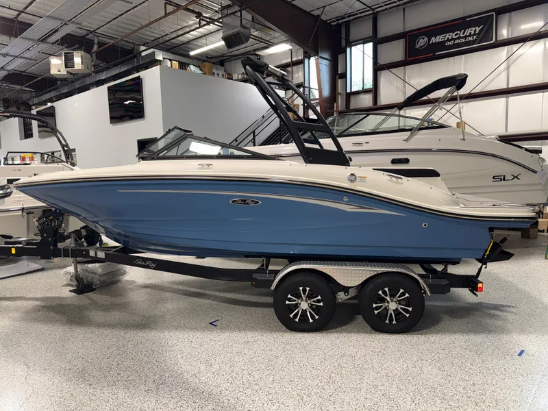 Slide: The Image of 2023 Sea Ray SPX 190 boat in showroom, blue hull, on trailer. - 5